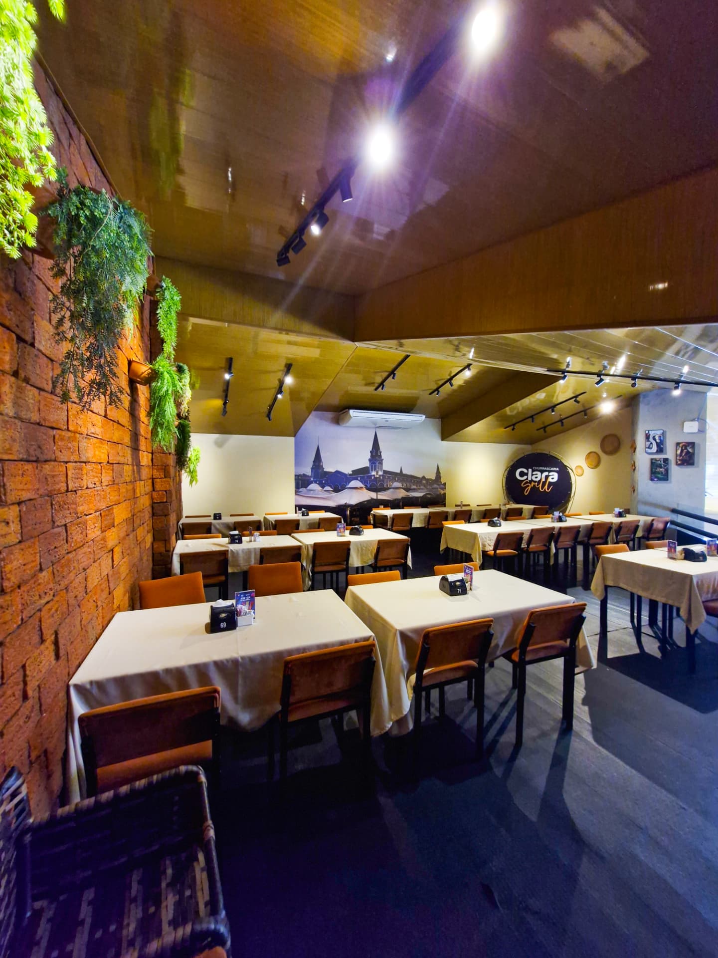 Mezanino da Clara Grill com parede de tijolos e painel do Ver-o-Peso